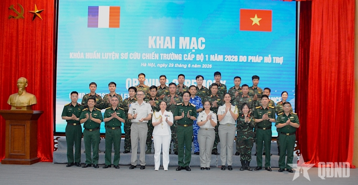 Le Général de brigade Pham Manh Thang, chef du Département du maintien de la paix du Vietnam et le Capitaine de vaisseau Anne Brun entourés des formatrices et des stagiaires<br>
Photo: QĐND