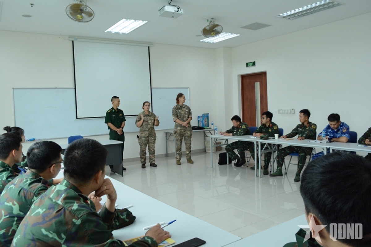 Les deux formatrices de l'armée française échangent avec les stagiaires vietnamiens lors de la formation CFAT/SC1<br>
Photo: QĐND