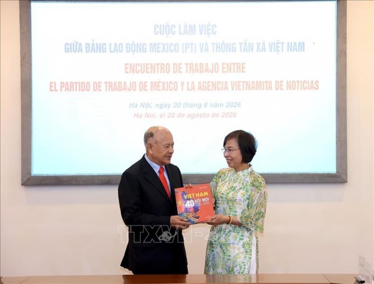 La directora general de la VNA, Vu Viet Trang, entrega el libro de fotografías "Vietnam: 40 años de renovación" al secretario general del Partido del Trabajo de México, Alberto Anaya Gutiérrez. Foto: Tuan Anh/VNA