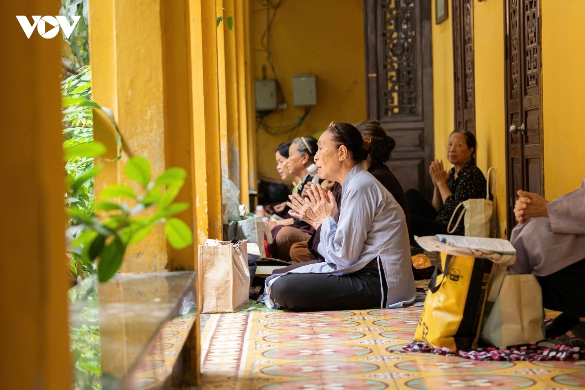 Dọc hành lang quanh chùa, nhiều phật tử ngồi hướng vào điện thờ chính để tham dự buổi lễ.
