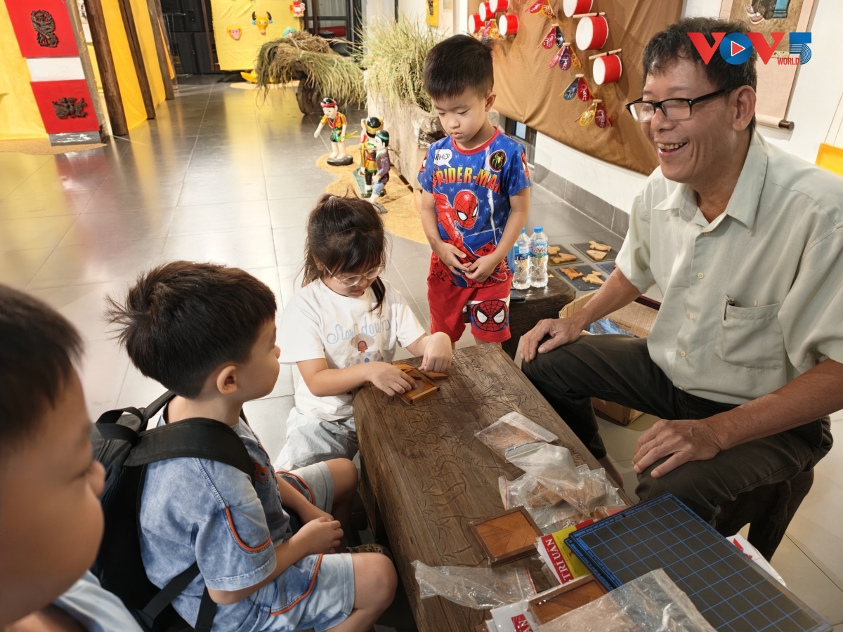 ຢູ່ສູນແລກປ່ຽນວັດທະນະທຳ​ຄຸ້ມ​ຖະ​ໜົນເກົ່າ ຮ່າໂນ້ຍ, ​ພວກເດັກນ້ອຍ​ພວມ​ເມົາ​ມົວກັບການຕອບຄຳທວຍຂອງປ່ຽງໄມ້ເຈັດອັນໃນການລະຫຼິ້ນ "ຈີອວນ".