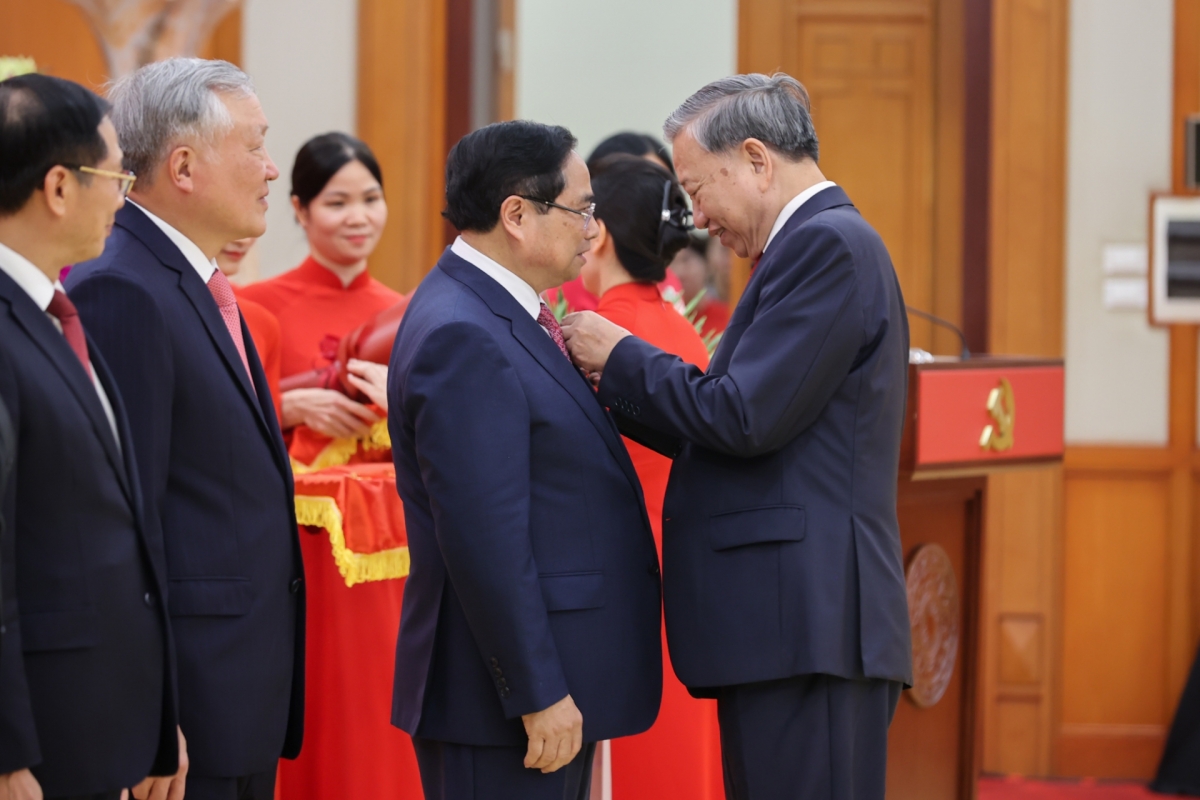KPV-Generalsekretär To Lam überreicht den Militärverdienstorden erster Klasse und das Parteiabzeichen für 40-jährige Parteimitgliedschaft an Premierminister Pham Minh Chinh. (Foto: VGP/Nhat Bac)