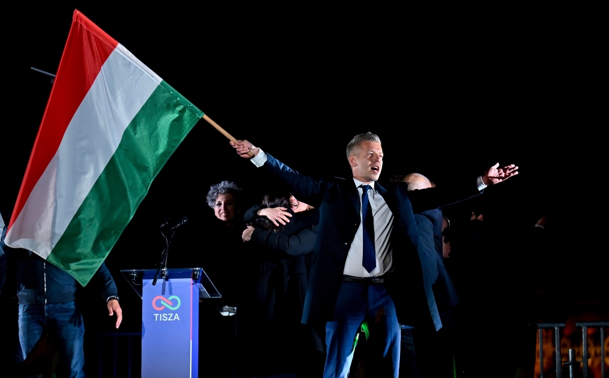 Peter Magyar, chef du parti d’opposition Tisza, brandit le drapeau hongrois après l’annonce des résultats partiels des élections législatives, à Budapest (Hongrie), le 12 avril 2026. Photo: AP/Denes Erdos