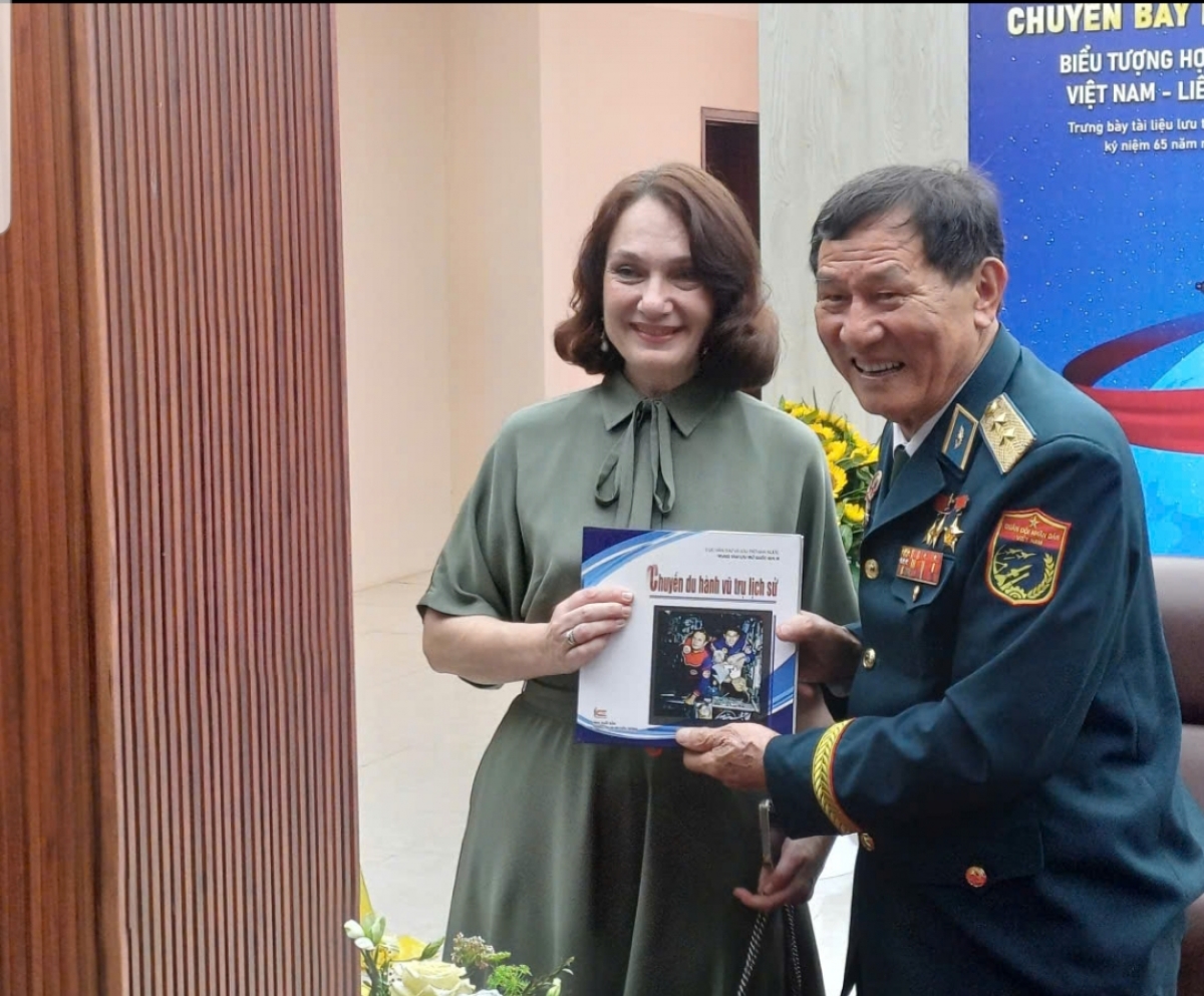 Генерал-лейтенант Фам Туан вручил в дар книгу посетительнице выставки.  Фото: Нгок Ань 