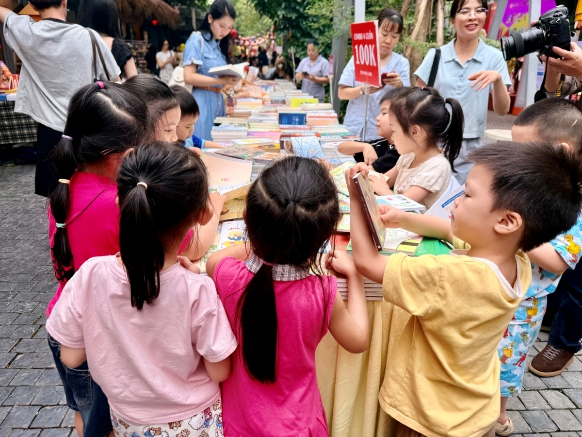 Kinder der Hauptstadt lesen begeistert interessante Bücher in der Bücherstraße. (Foto: Bich Ngoc)