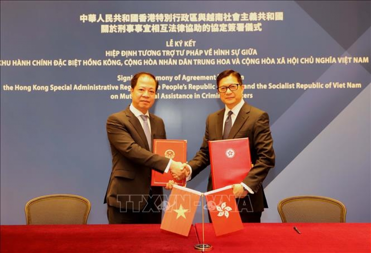 Phó Viện trưởng Viện Kiểm sát nhân dân tối cao Trần Hải Quân và Cục trưởng Cục An ninh Hong Kong Đặng Bính Cường ký kết hiệp định. Ảnh: Xuân Vịnh/PV TTXVN tại Hong Kong