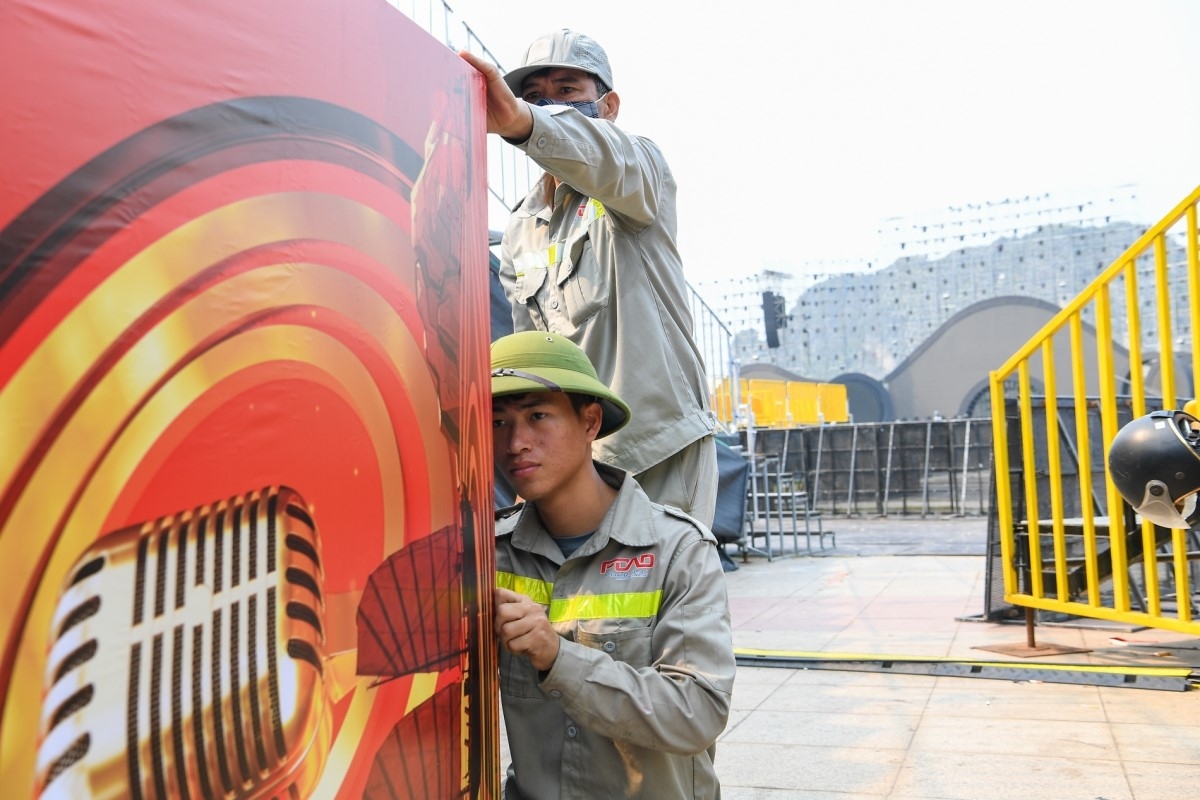Đó là quá trình lao động nghiêm túc, sáng tạo, nơi mỗi âm thanh, mỗi câu chữ đều được chăm chút để chạm tới cảm xúc người nghe. (Ảnh: Công nhân thực hiện những khâu cuối trước giờ khai mạc)