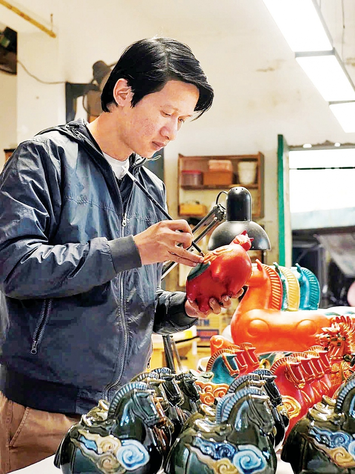 Họa sĩ Lê Huy tô mầu hoàn thành “Ngựa mây Bính Ngọ”. Ảnh: nhandan.vn