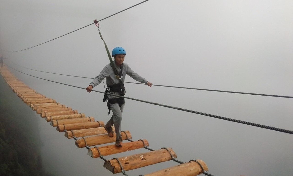 Ein Besucher erlebt die Hängebrücke im Tourismusgebiet „Rong-May-Glasbrücke“ am O-Quy-Ho-Pass. (Foto: nguoiquansat.vn)