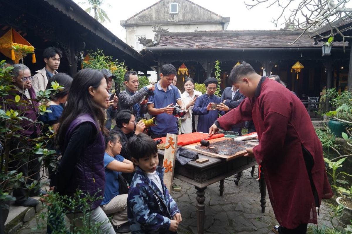 Young artisan Pham Cong Dat demonstrates the process of hand-printing the calligraphic scrolls on poonah paper. (Photo credit: Sofitel Legend Metropole Hanoi)