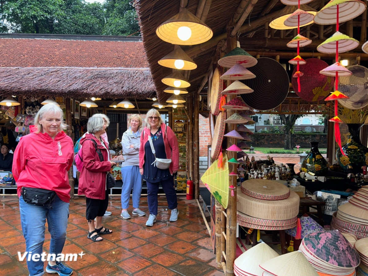 Des visiteurs étrangers découvrent les produits artisanaux traditionnels au Temple de la Littérature à Hanoi. Photo: Mai Mai/TTXVN