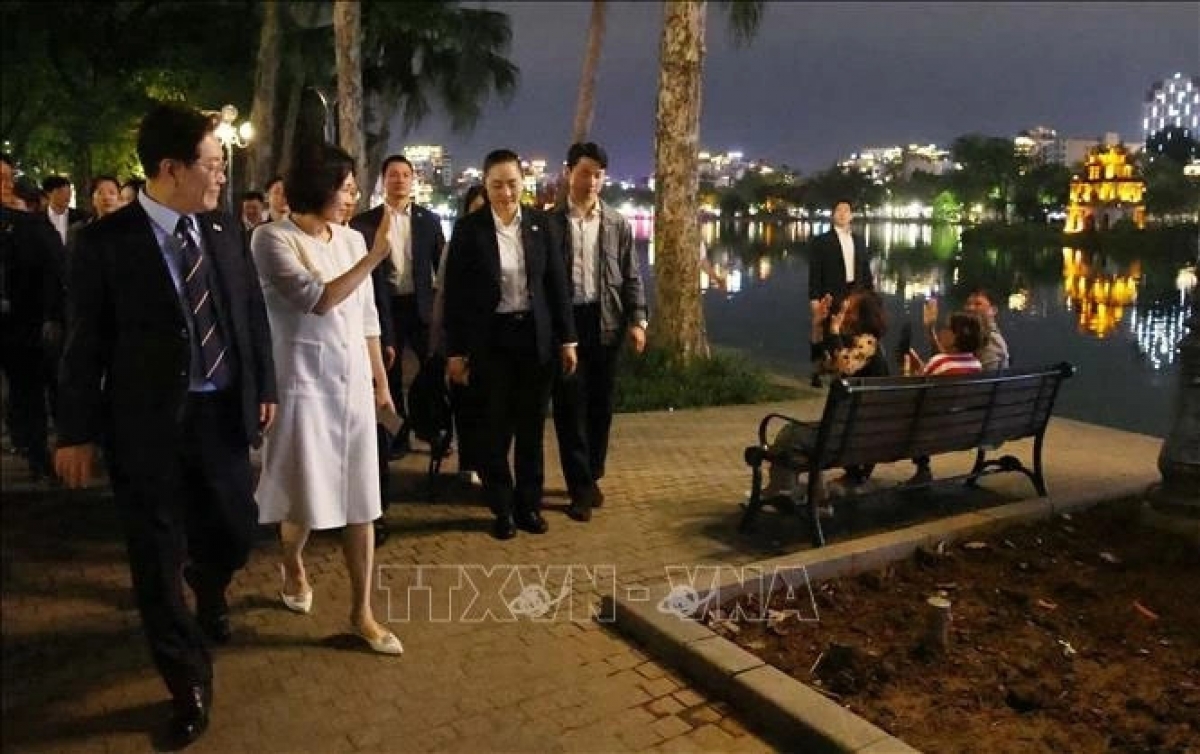 호안끼엠 호수 주변에서 하노이 시민들을 향해 손을 흔들며 인사하는 이재명 대통령 내외 (사진: 베트남 통신사)