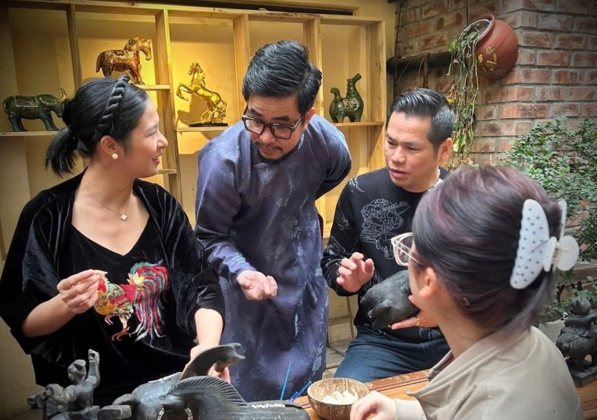 Nguyên Tân Phat échange sur l'art de la laque avec ses confrères. Photo: VOV
