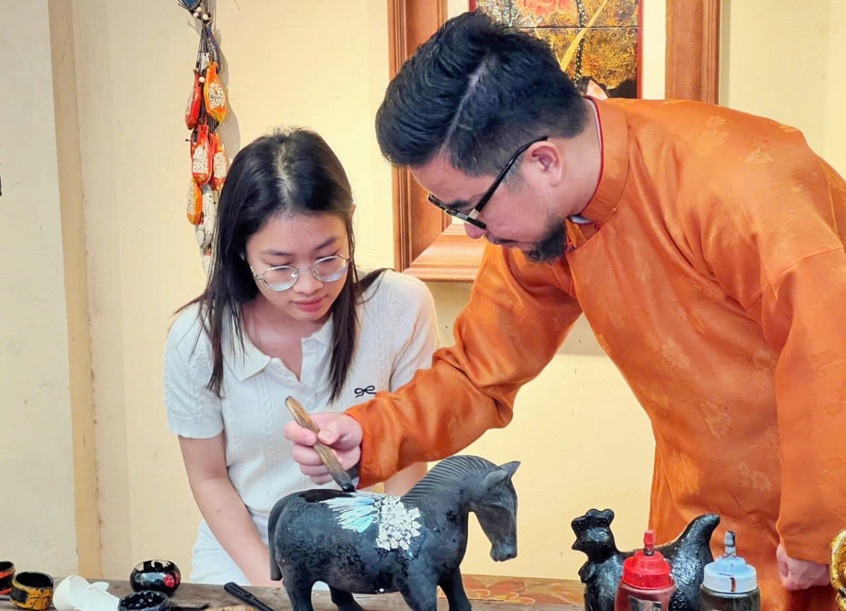 Nguyen Tan Phat guides young people in making traditional lacquerware products. (Photo: Kim Lieu/VOV5)