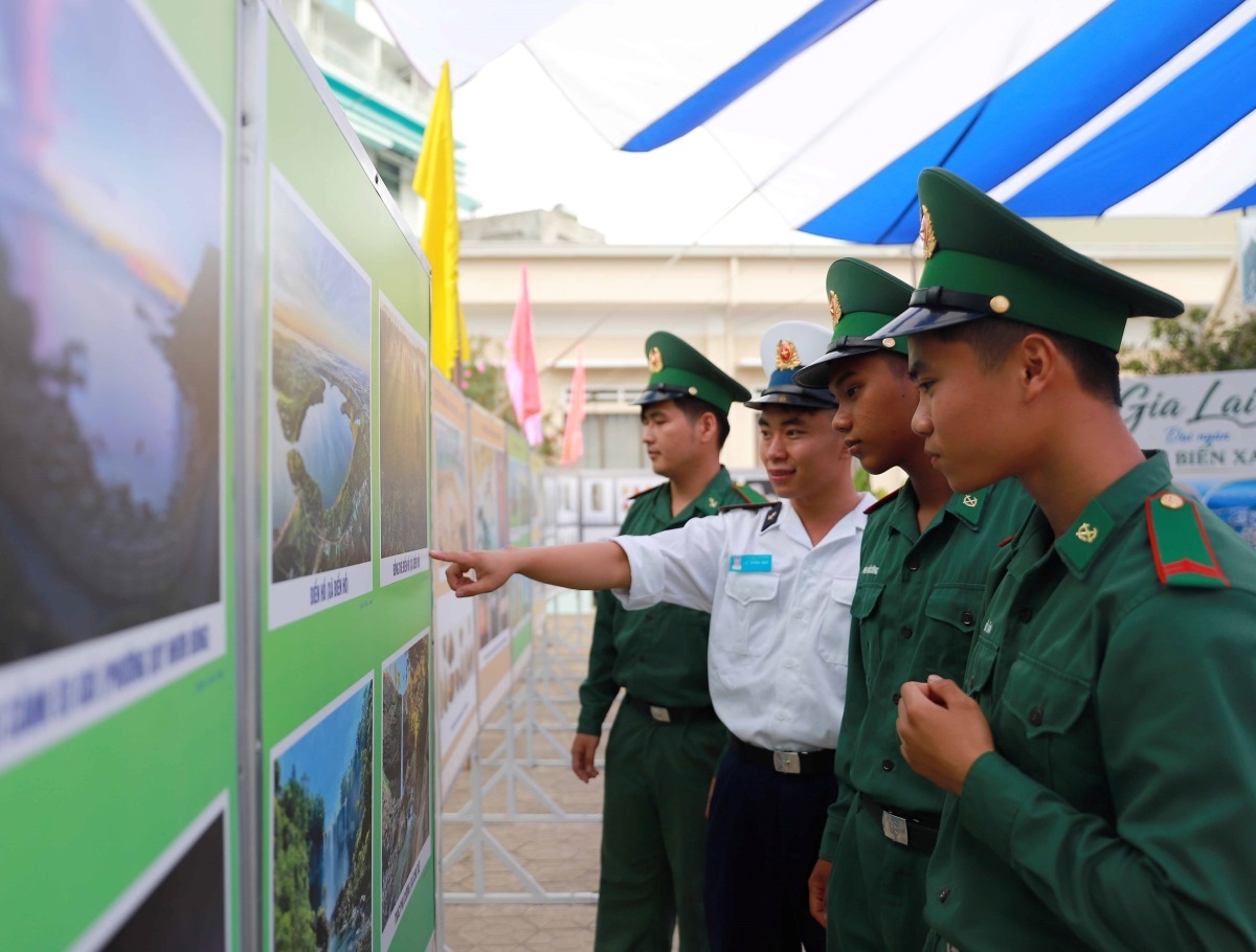 Các chiến sĩ biên phòng chăm chú xem ảnh trưng bày. Ảnh: baovanhoa.vn