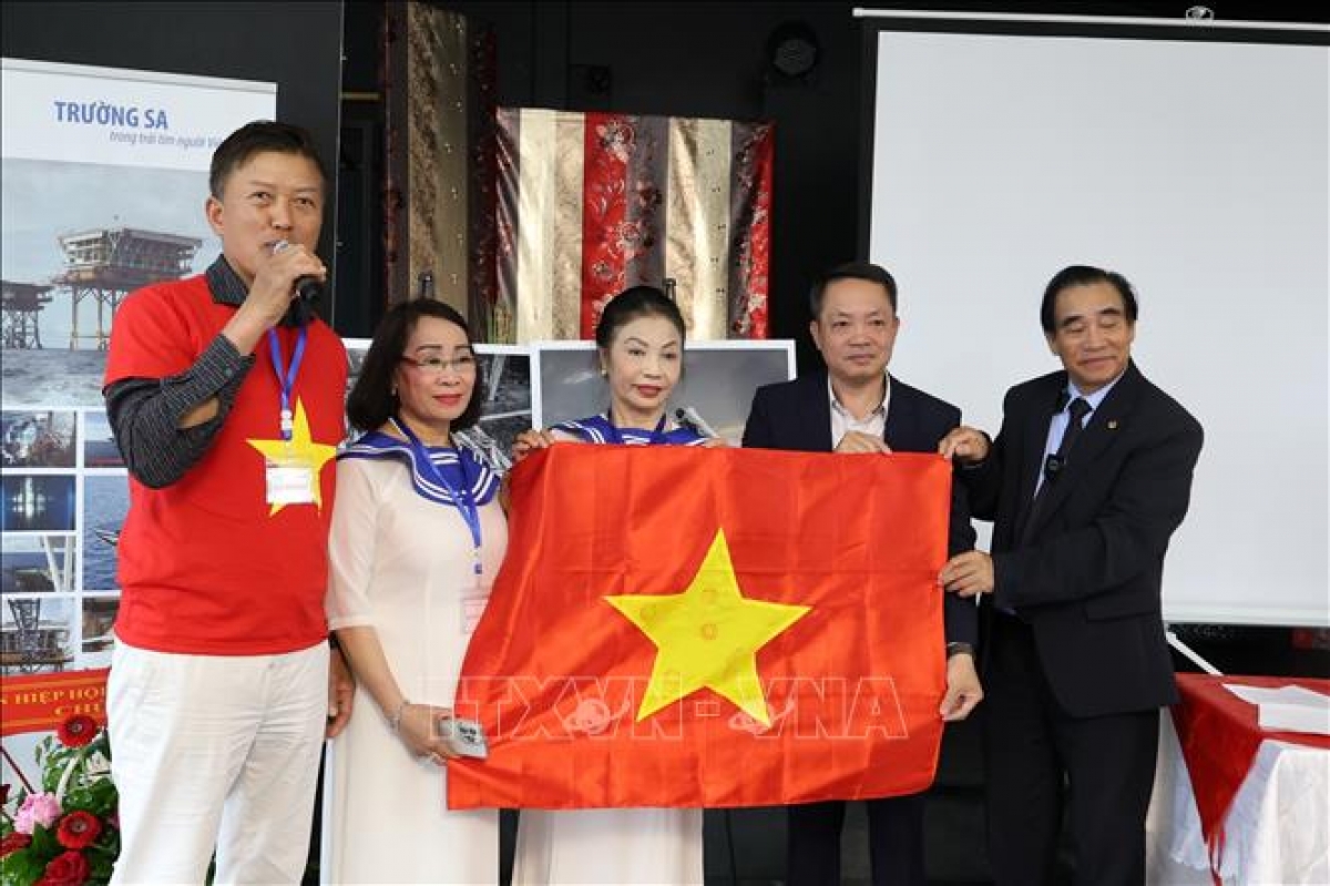 Trao tặng CLB Trường Sa lá cờ Tổ quốc có đóng dấu của những điểm đảo và vùng biển. Ảnh: TTXVN