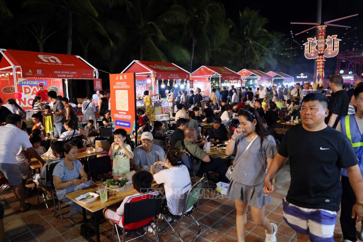 Zahlreiche Einheimische sowie internationale Besucher genießen das Essen an den Ständen während des Küche-Festivals. (Foto: Tran Le Lam/VNA)