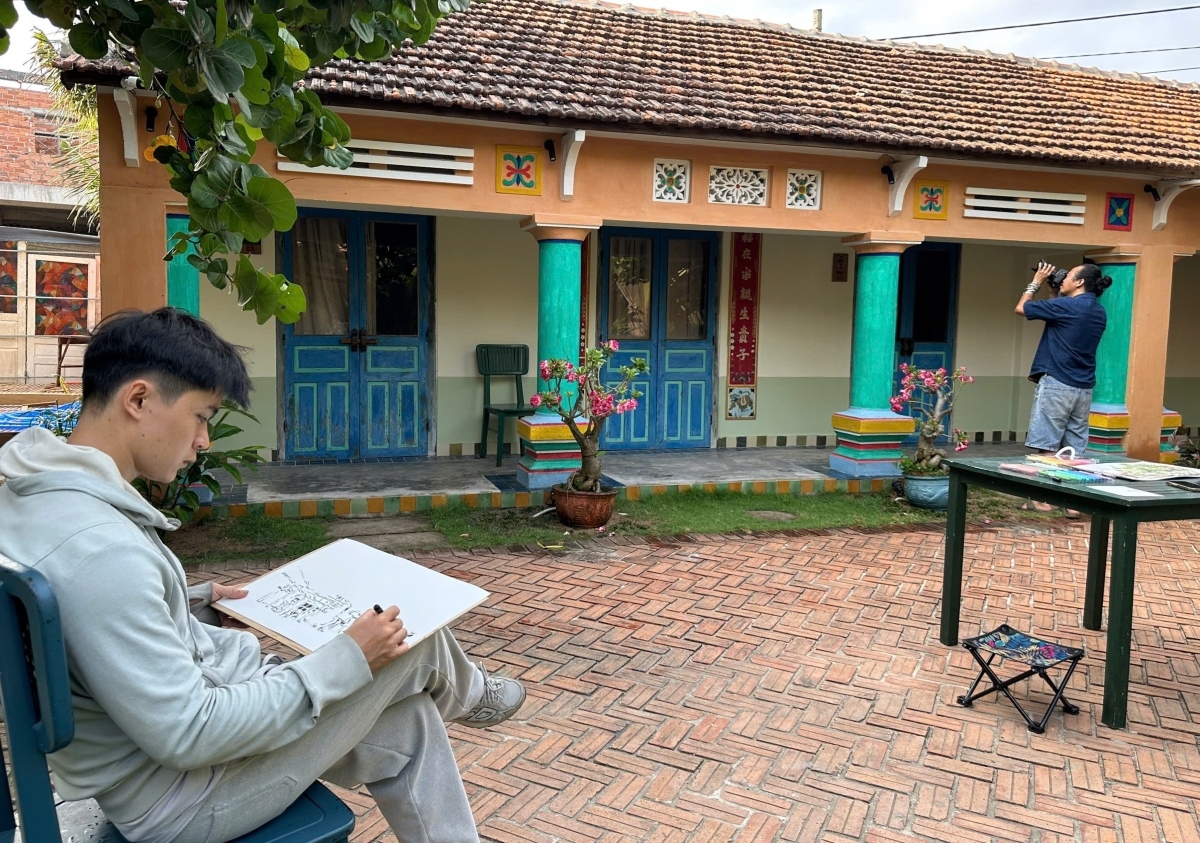 El arquitecto Phan Dinh Trung dibuja una casa patrimonial de la aldea Lo. Foto: Le Biet/VOV