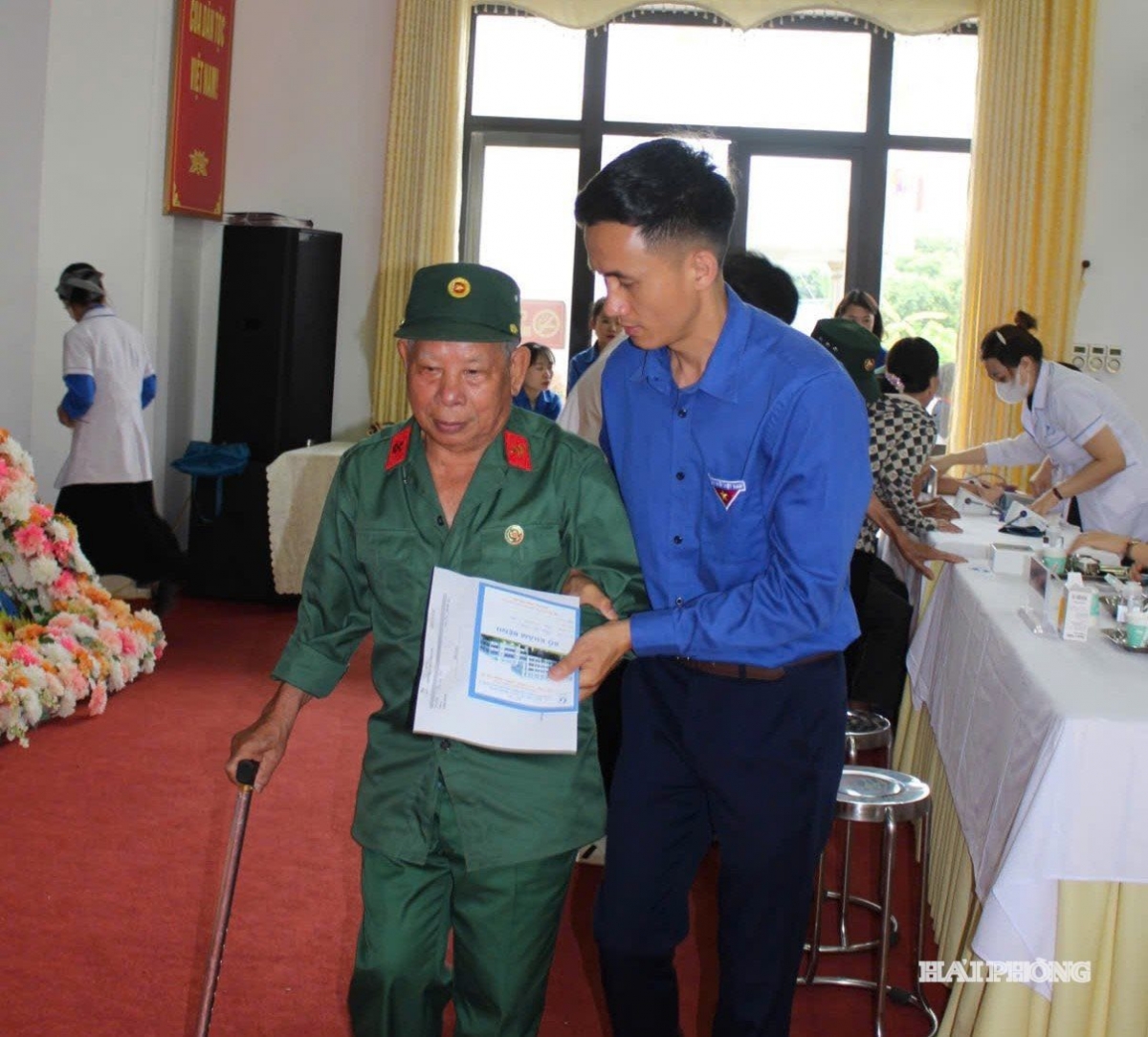 Các cựu thanh niên xung phong được các thanh niên tình nguyện hướng dẫn khám, chữa bệnh. Ảnh: Báo Hải Phòng