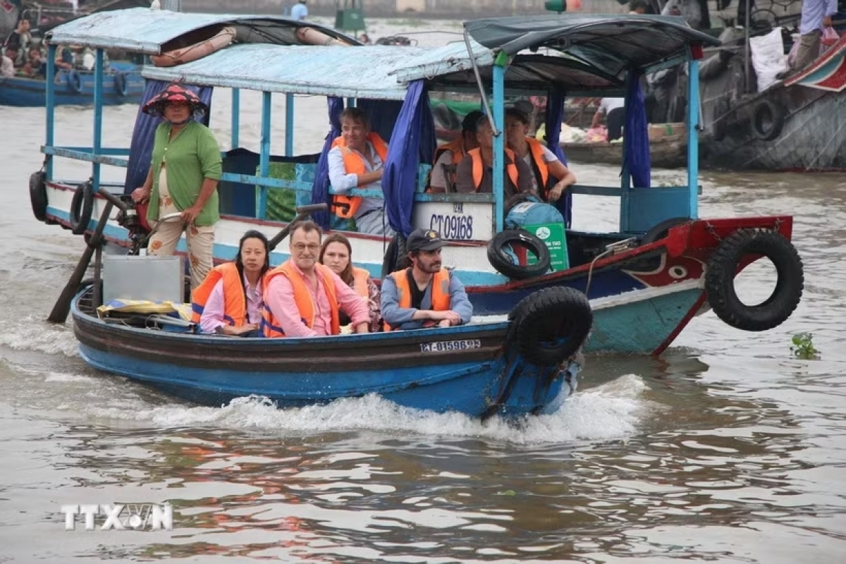 Ausländische Touristen besuchen den schwimmenden Cai-Rang-Markt. (Foto: Nguyen Hang/VNA)