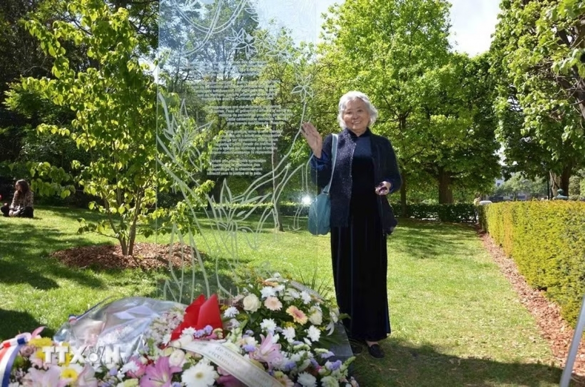Tran To Nga next to a memorial plaque dedicated to Agent Orange/dioxin victims at Choisy Park in Paris (Photo: VNA)