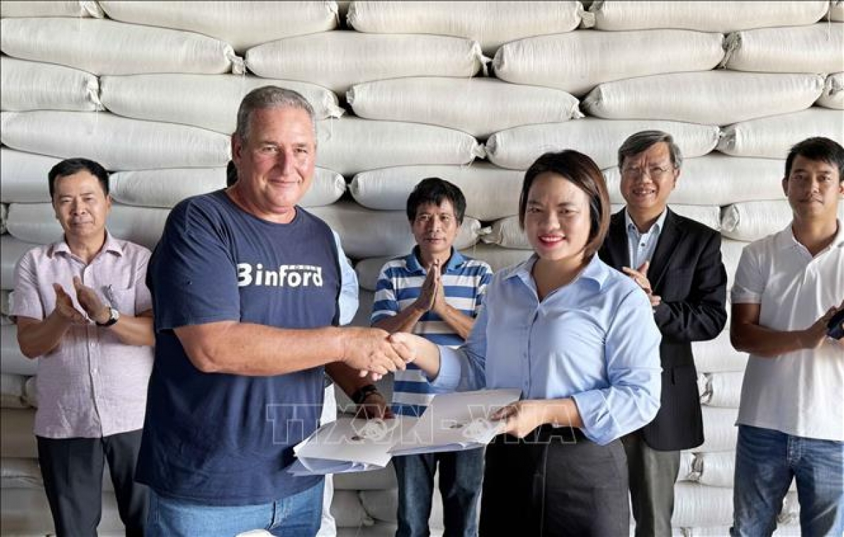 Nguyen Thi Thom, directora de AgriVMA, y Michel Ballate Camejo, director general de Los Palacios, firman un contrato de entrega de arroz. Foto: VNA