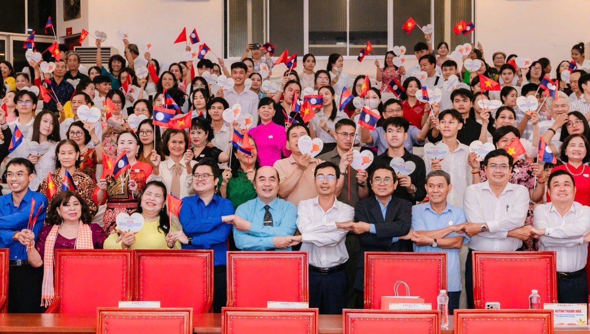 ບັນ​ດາ​ຜູ້​ແທນ​ພ້ອມ​ດ້ວຍ​ບັນ​ດາ​ຄອບ​ຄົວ ຫວຽດ​ນາມ ແລະ ນັກ​ສຶກ​ສາ ລາວ, ກຳ​ປູ​ເຈຍ ຖ່າຍ​ຮູບ​ເປັນ​ທີ່​ລະ​ນຶກ​ໃນ​ພິ​ທີ (ພາບ:  sggp.org.vn)