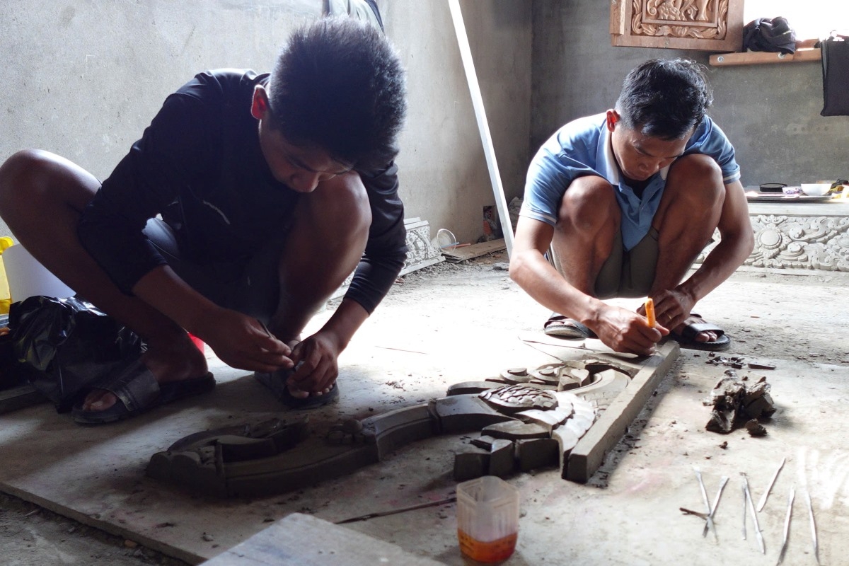 Son Thanh Tuan (R) works on his sculpture. (Photo: Se Ray/VOV reporter in the Mekong Delta)
