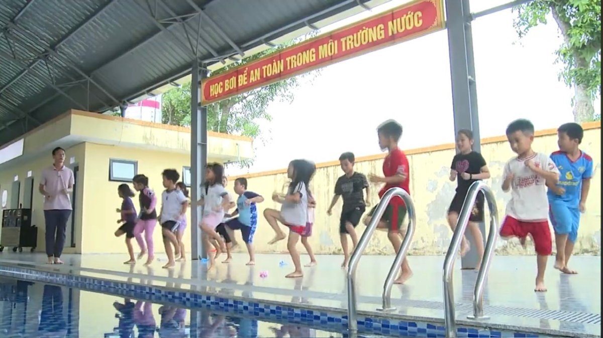Các em học sinh được hướng dẫn khởi động kỹ trước khi xuống nước. Ảnh: VOV1