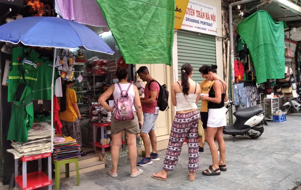 Desde pequeños puestos en las calles antiguas de Hanói hasta servicios de transporte y alojamiento, no es difícil ver a turistas extranjeros escaneando códigos QR y pagando directamente con la aplicación bancaria de su país en apenas unos segundos. Foto: Le Chi/VOV5