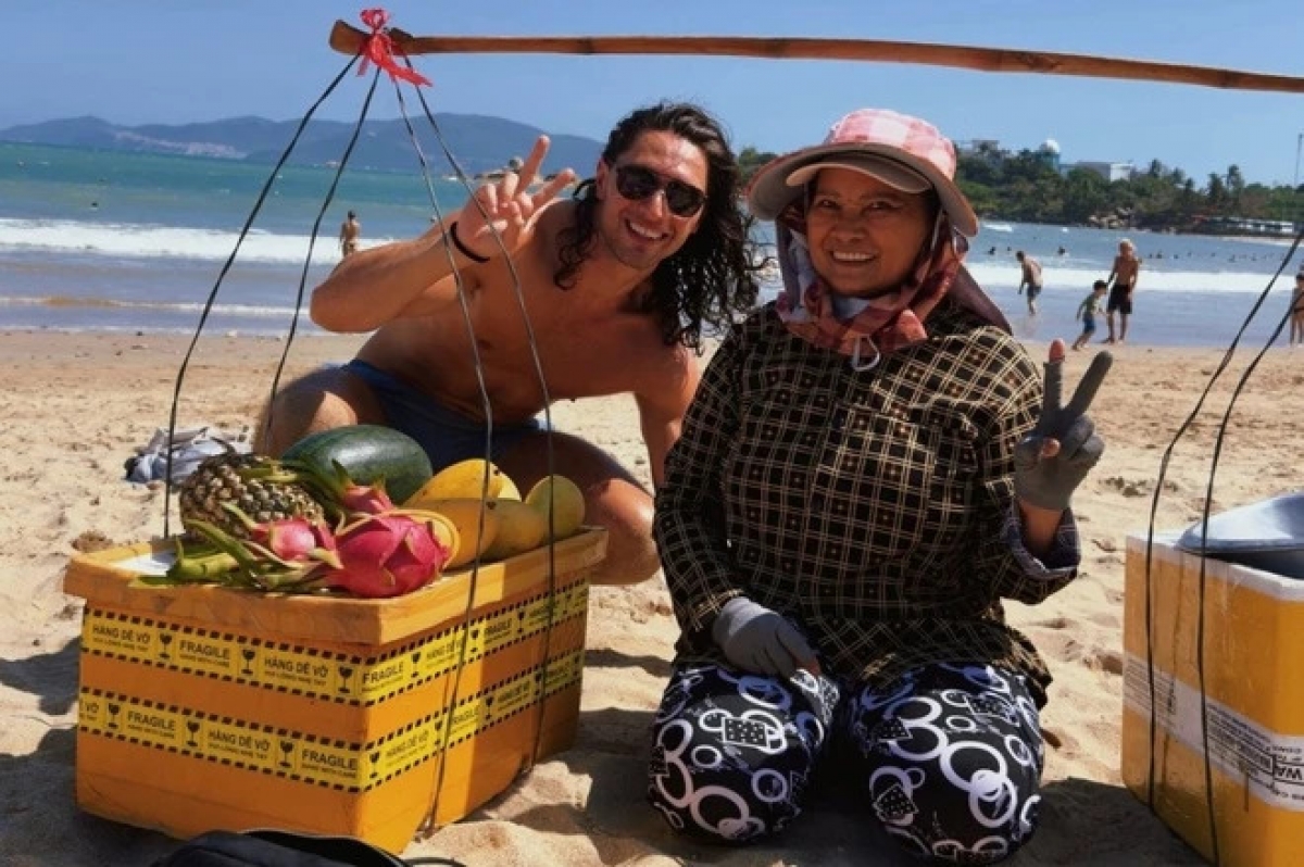 Tourist Louis and aunty Mai, a Vietnamese fruit vendor by Nha Trang beach (Photo: Znews.vn)