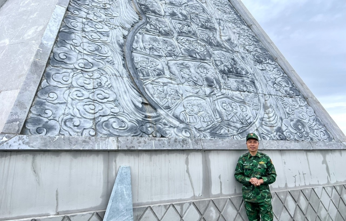 Майор Динь Куок Тап рассказывает о барельефе, посвящённом 19 этническим народностям провинции Дьенбьен. Фото: VOV