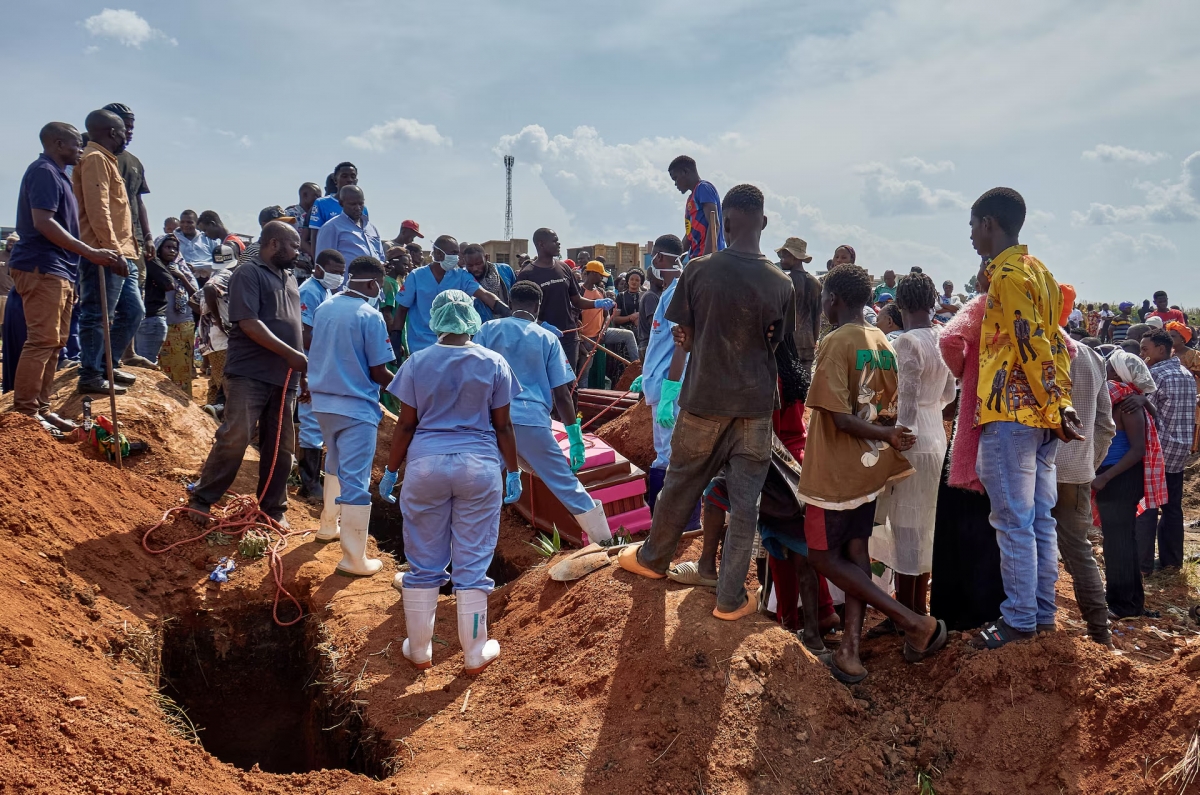 Red Cross workers handle the coffin of a man who died of Ebola virus before his burial, as aid agencies intensify efforts to contain the Ebola outbreak caused by the Bundibugyo virus, at the Nyamurongo cemetery in Bunia town, Ituri province, Democratic Republic of Congo, June 10, 2026. (REUTERS/Gradel Muyisa Mumbere)
