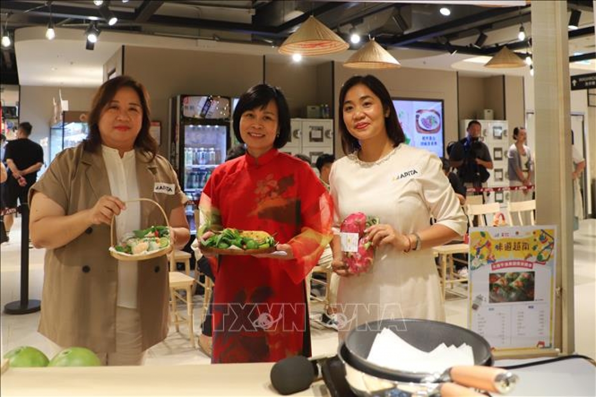 Bà Lê Đức Hạnh, Tổng Lãnh sự Việt Nam tại Hong Kong (Trung Quốc) và bà Vũ Thị Thúy, Phó Tổng lãnh sự, Trưởng Thương vụ Việt Nam tại Hong Kong cùng đại diện Ban lãnh đạo của hệ thống siêu thị APITA Hong Kong tại gian hàng đồ ăn Việt. Ảnh: Trần Thị Lê Anh/PV TTXVN tại Hong Kong
