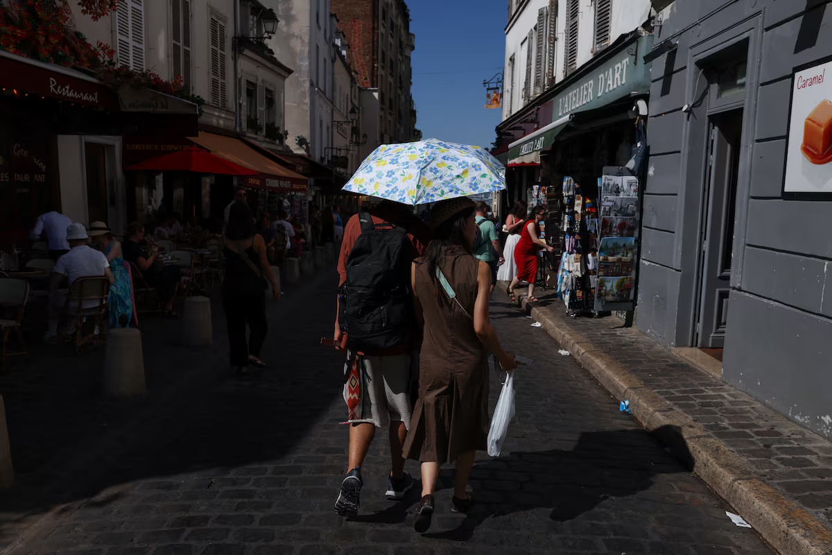 Des passants s'abritent sous leurs parapluies dans une rue de Montmartre, à Paris, lors de la canicule du 12 juillet. Photo: Reuters