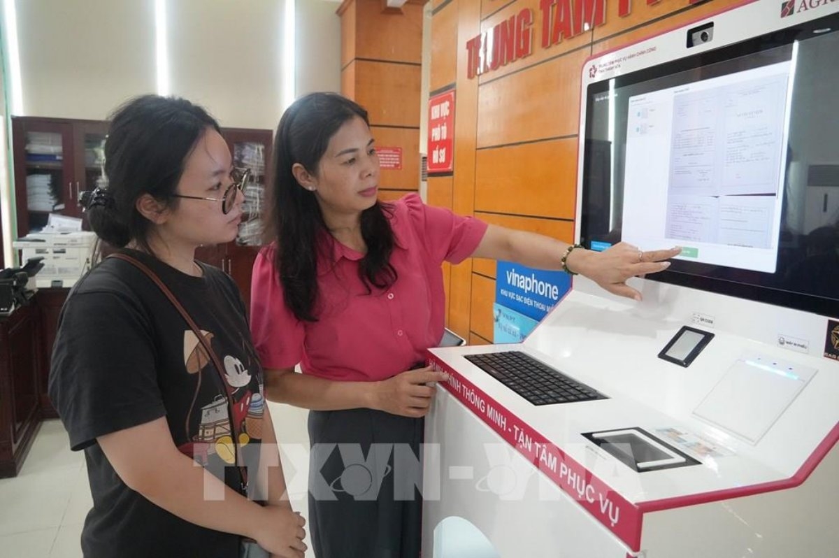 Warga memproses permohonan mereka di kios pintar yang terletak di pusat layanan administrasi publik setempat. Foto: Khieu Tu/VNA