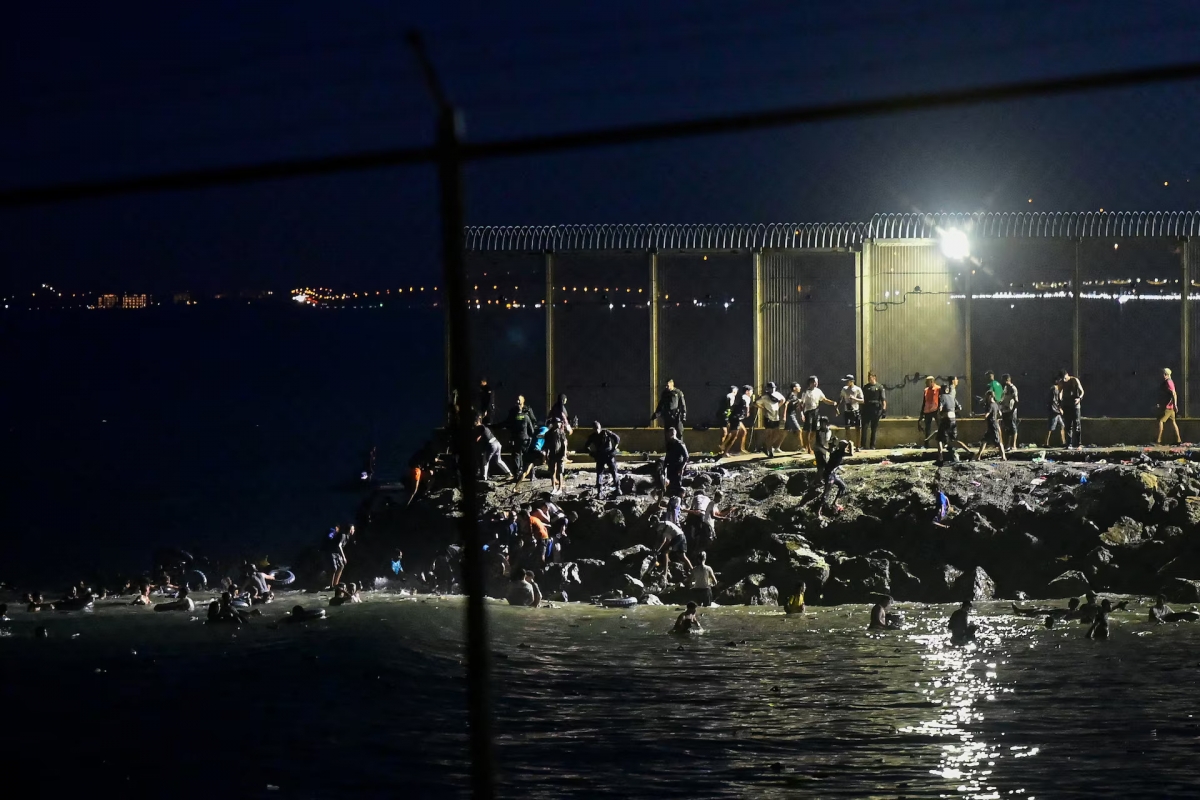 Des migrants marocains traversent la frontière maritime pour rejoindre Ceuta et se rassemblent près de la clôture frontalière entre le territoire espagnol de Ceuta et le Maroc, le 30 juillet 2026. Photo : REUTERS/Fabian Bimmer