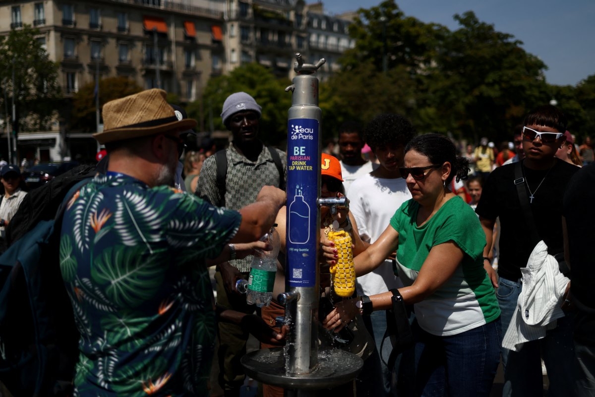 Des personnes remplissent leurs bouteilles d’eau à une fontaine publique près de la place du Trocadéro, à Paris, le 27 juin 2026. Photo: REUTERS/Tom Nicholson.