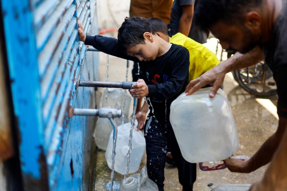 Palestinians fill jerrycans with water at a water distribution point, in Nuseirat, central Gaza Strip, on July 15, 2026. (REUTERS/Mahmoud Issa)