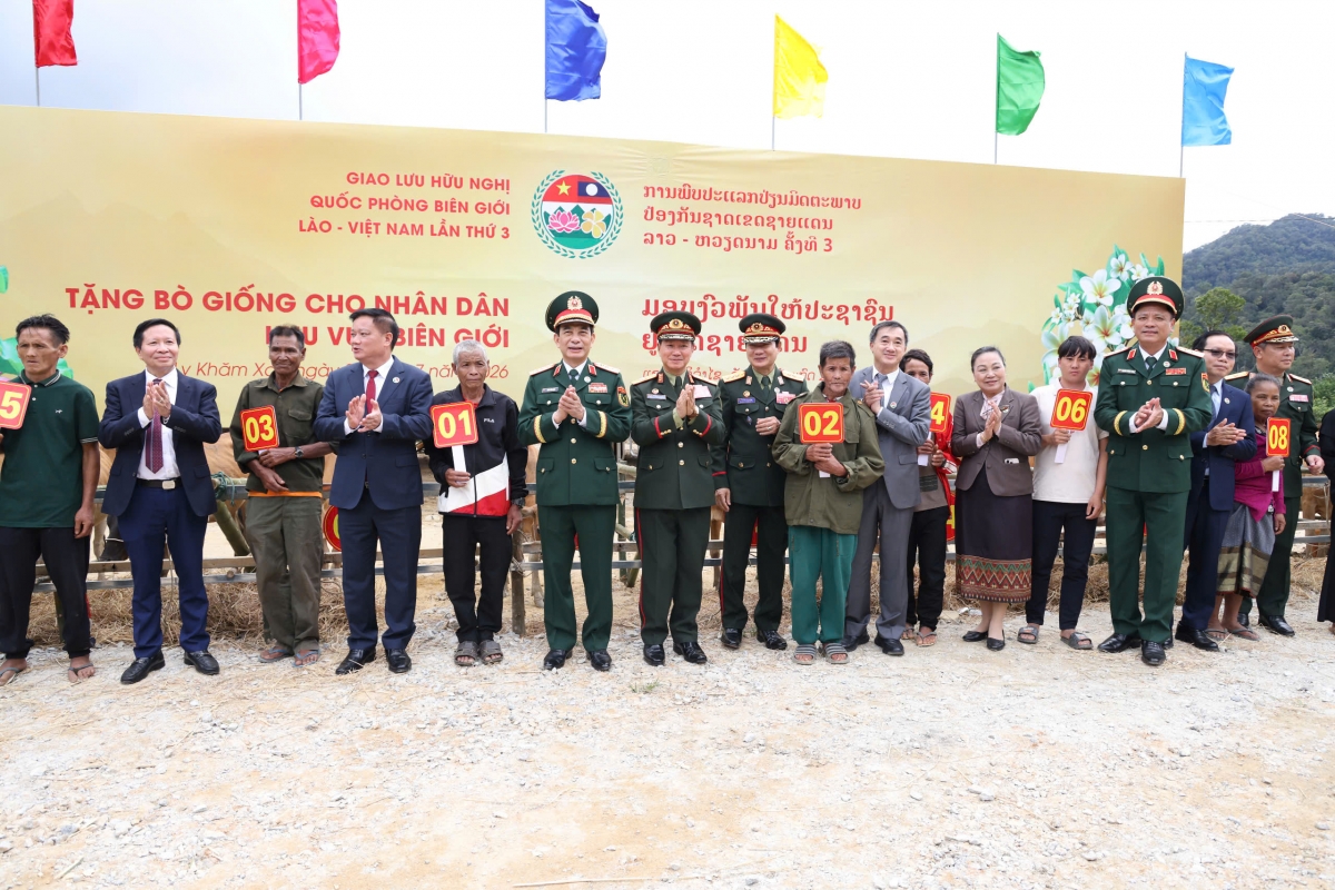 Hai Bộ trưởng trao tặng bò giống cho các hộ gia đình khó khăn ở khu vực biên giới Lào – Việt Nam. (Ảnh: Gian Phan/QPVN)
