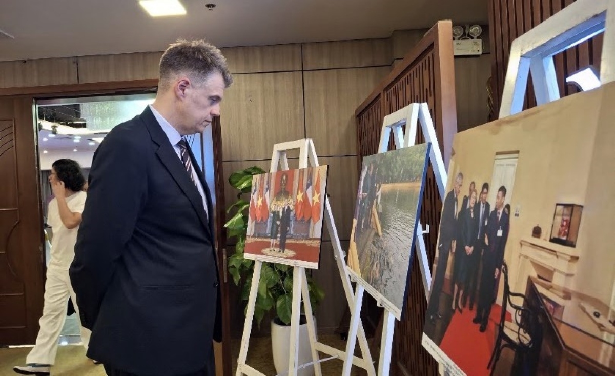 A delegate watches the photo exhibition. (Photo: Dinh Thieu/VOV-Central Region)
