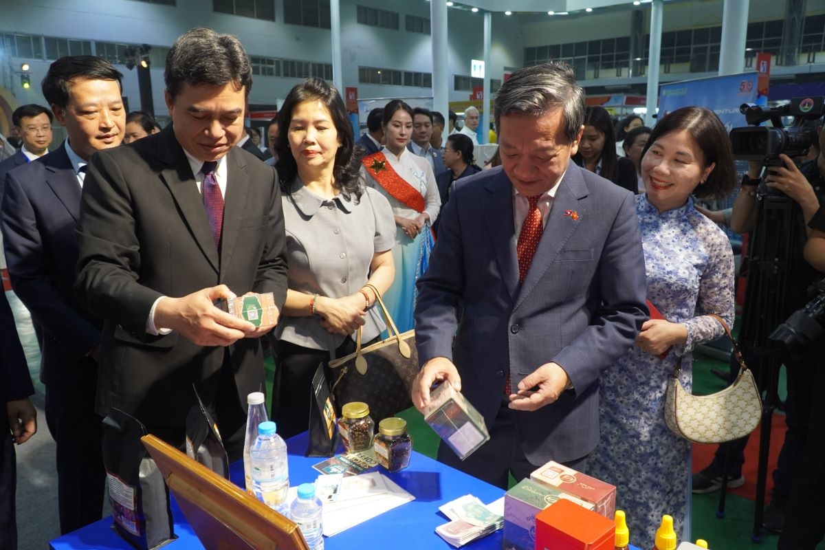 Đại sứ Việt Nam tại Lào Nguyễn Minh Tâm (phải) và Thứ trưởng Bộ Công thương Lào Phoutthavan Namthavong tham quan các gian hàng tại hội chợ. Ảnh: Trần Tuấn/VOV-Vientiane
