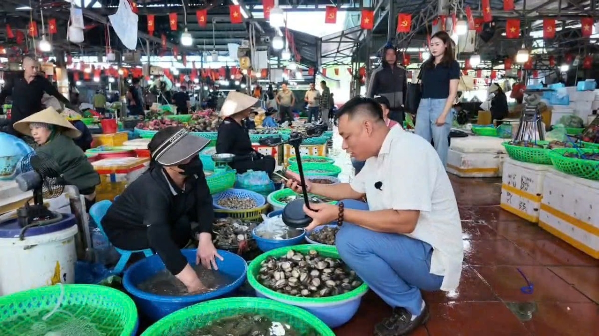 Tran Thanh Trung Direktur Pusat Transformasi Digital Pasar Ha Long I memberikan panduan kepada pedagang tentang transformasi digital (Foto: Vu Mien/VOV Dong Bac)