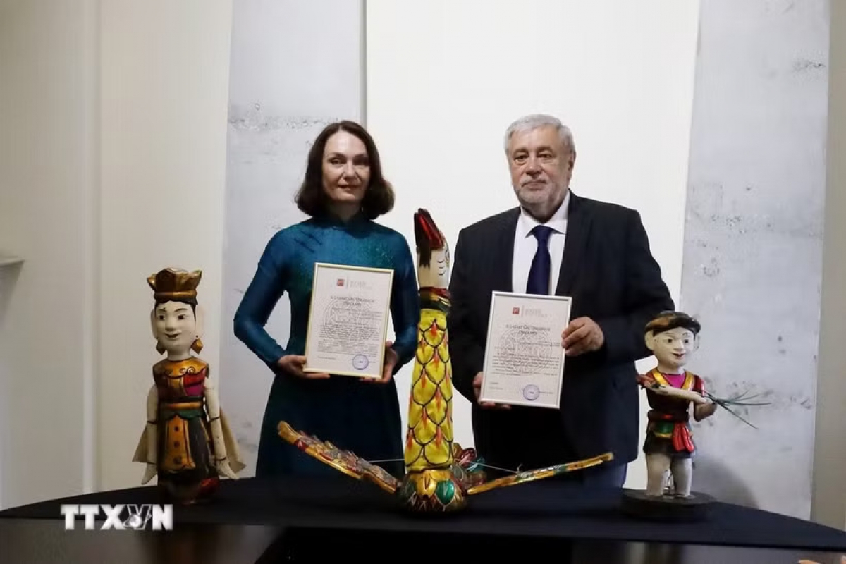 Елена Бездетко (слева), супруга Чрезвычайного и Полномочного Посла Российской Федерации во Вьетнаме Геннадия Бездетко, передает экспонаты, подаренные Ханойским театром кукол на воде «Тханглонг» Государственному музею Востока. Фото: Ван Хиеу/ВИА.