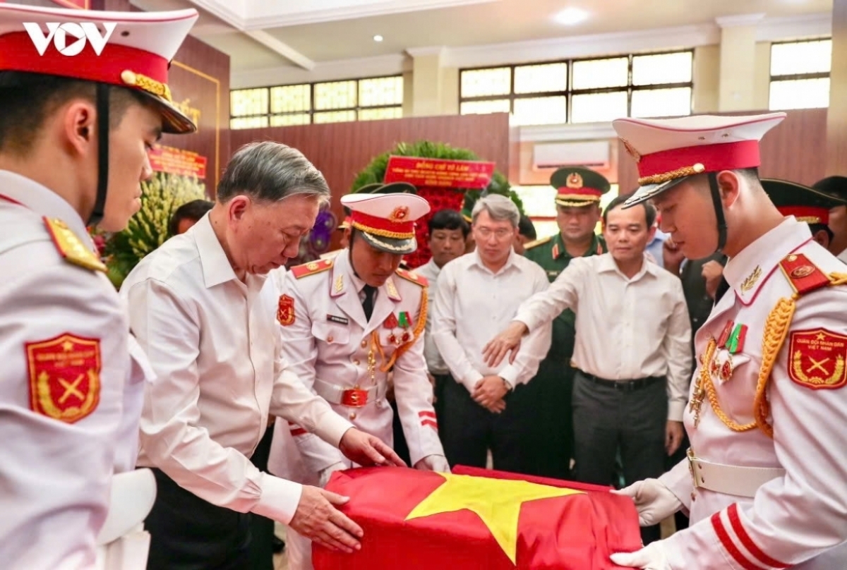 Sekretaris Jenderal sekaligus Presiden To Lam melakukan upacara membentangkan bendera nasional di atas kerangka martir yang ditemukan di Taman Le Thi Rieng. Foto: VOV.