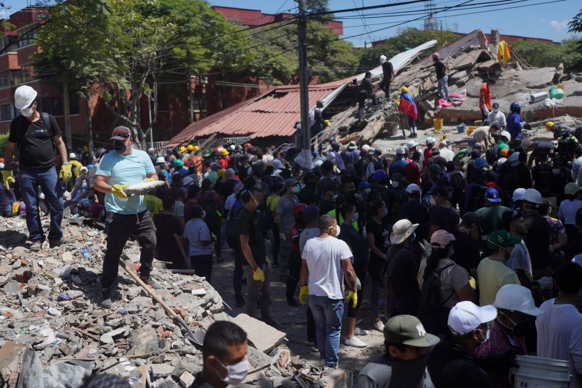 Residents clear debris in search for survivors the day after an earthquake struck Cali, Colombia, Aug. 11, 2026. (Photo: AP/Ivan Valencia)