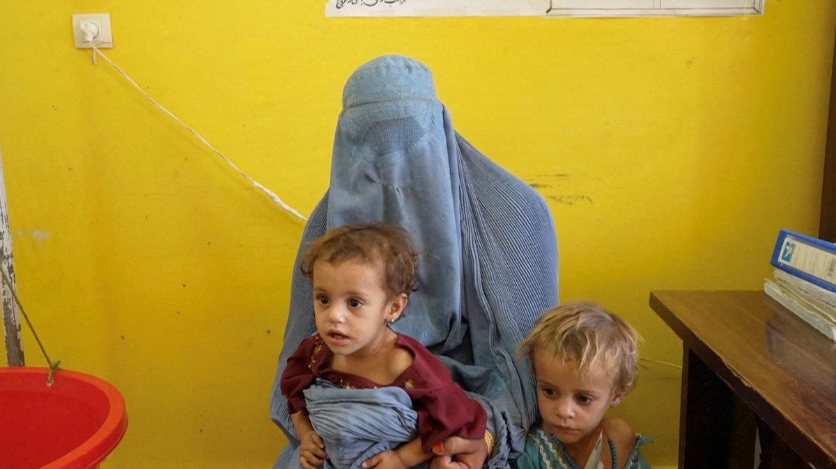 Sadiqa, 30 ans, originaire de Helmand, aux côtés de ses deux filles, Sofia et Nazdana, qui souffrent de malnutrition, dans une clinique de Helmand, en Afghanistan, le 14 juillet 2026. Photo: WFP/REUTERS.
