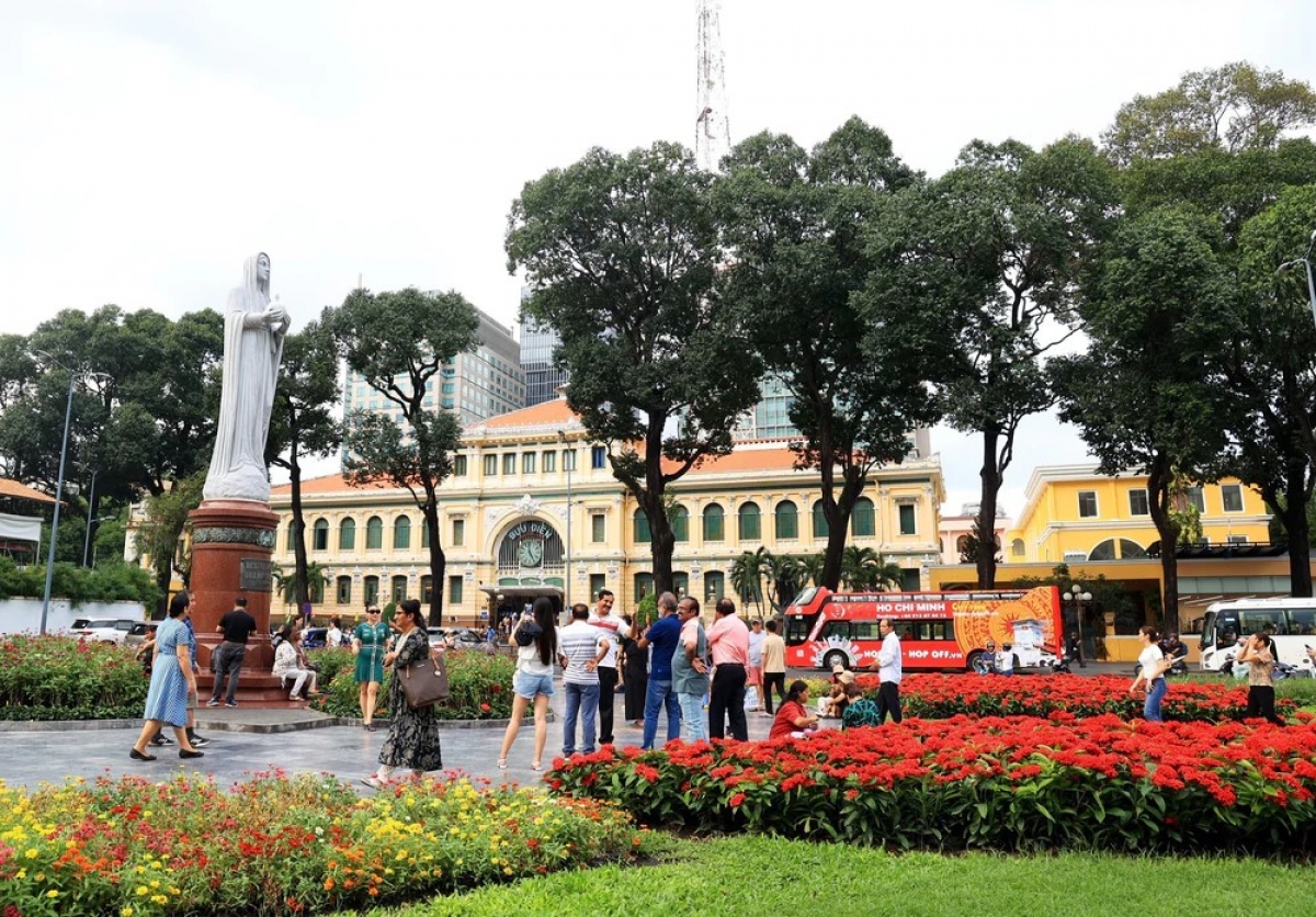 中央郵便局とサイゴン大教会前の花壇で楽しむ外国人観光客（写真：Hồng Đạt/TTXVN）