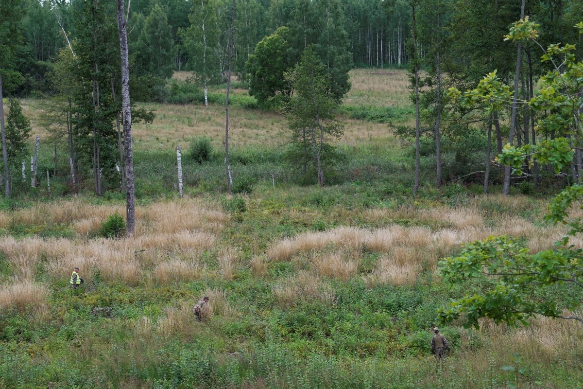 Servicemen of the Latvian National Guard walk on a field as they search for the debris from an intercepted drone in Rugaji, Latvia, on August 14, 2026. (Photo: REUTERS/Janis Laizans)