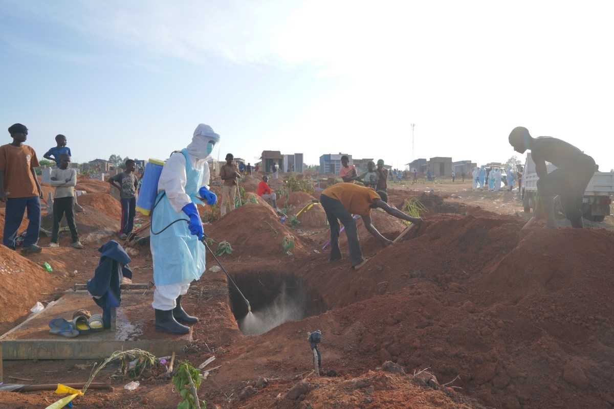 A health worker sprays disinfectant in a freshly dug grave for the body of Jacques Lobo Dhena, who died of Ebola, in Bunia, Ituri province, eastern Congo, on August 12, 2026. (Photo: AP/Dieudonne Dirole)